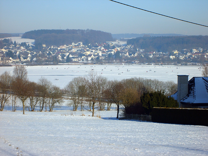 Verschneite Landschaft mit Blick auf den Wiesensee und die Ortschaft Stahlhofen im Hintergrund